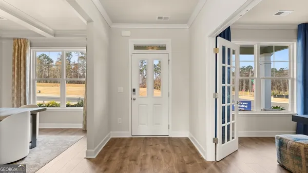 a view of an empty room with wooden floor and a window