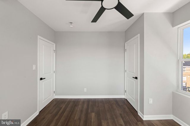 a view of a livingroom with wooden floor and a ceiling fan