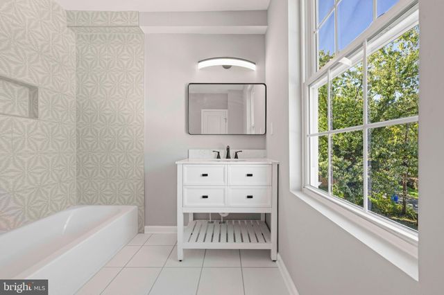 a kitchen with a sink stove and white cabinets with wooden floor