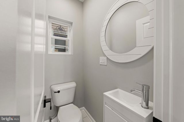 a bathroom with a sink mirror and a toilet