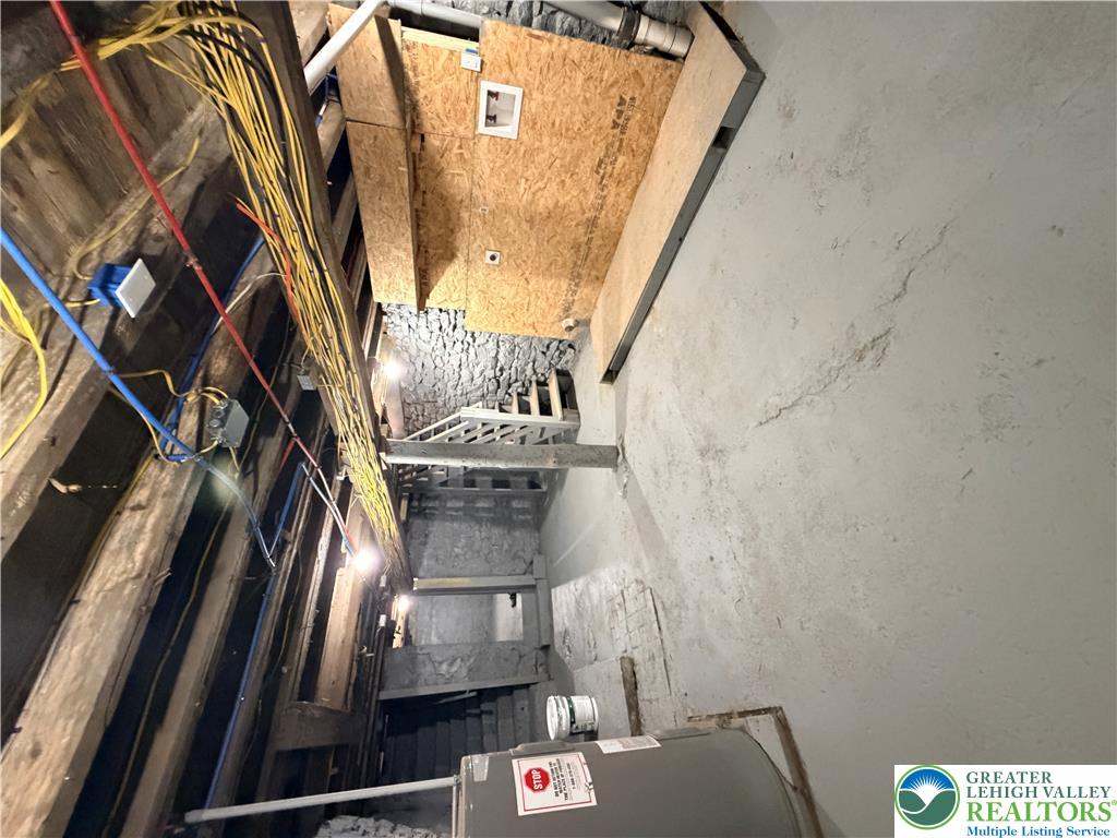 718 Ferry Street Easton, PA 18042 - Photo 34 of 37 The unfinished basement reveals robust structural beams and essential utilities.