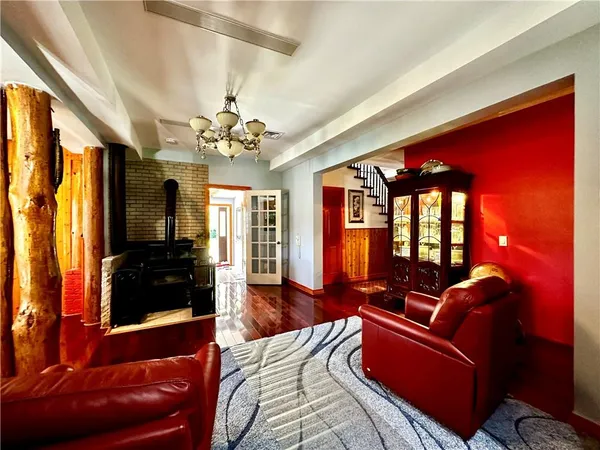 a living room with furniture a flat screen tv and a chandelier