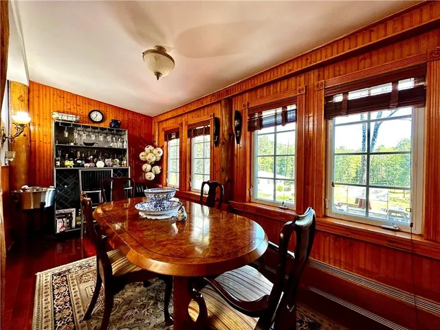 a dining room with furniture window and wooden floor