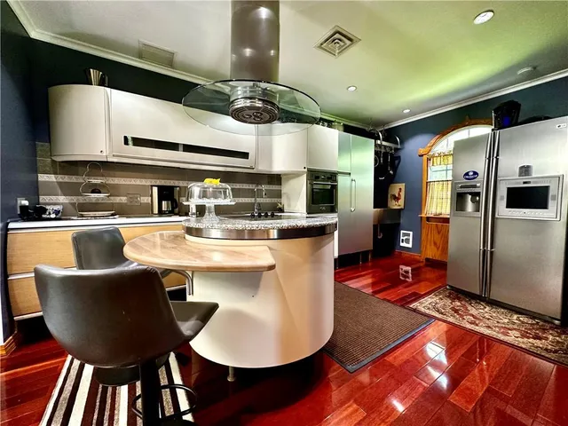a kitchen with stainless steel appliances granite countertop a sink a stove and a refrigerator