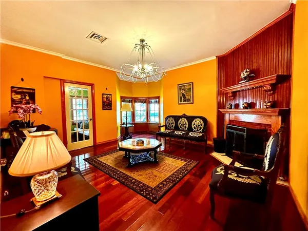 a living room with furniture a chandelier and a fireplace