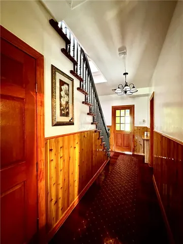 a view of entryway and hall with wooden floor