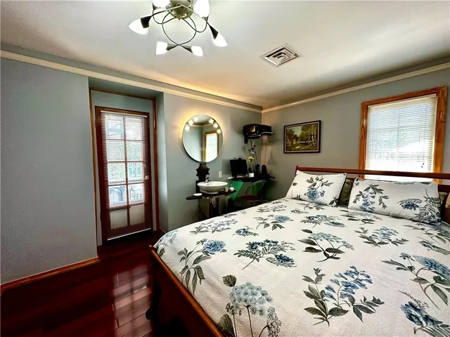 a bedroom with a bed mirror and a window