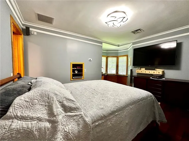 a bedroom with a bed and a flat screen tv