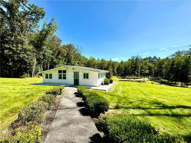 a view of a house with backyard and sitting area