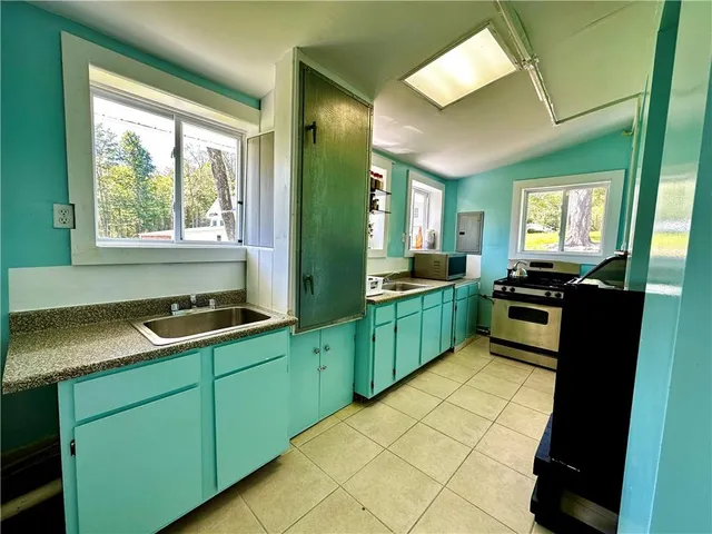 a bathroom with a toilet a sink a mirror a vanity and a window