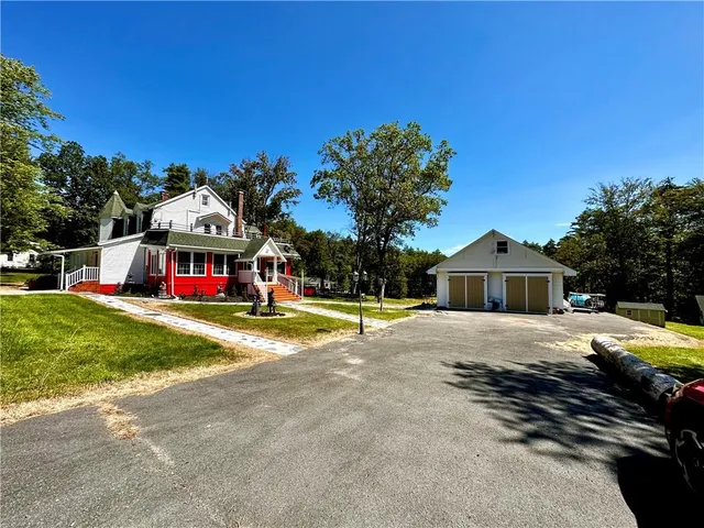 a view of a house with a big yard and large trees