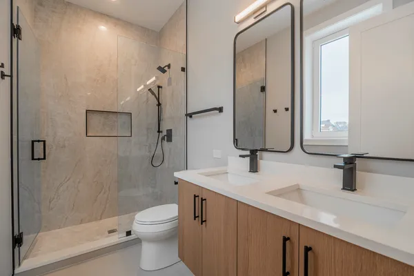 a bathroom with a double vanity sink toilet and shower