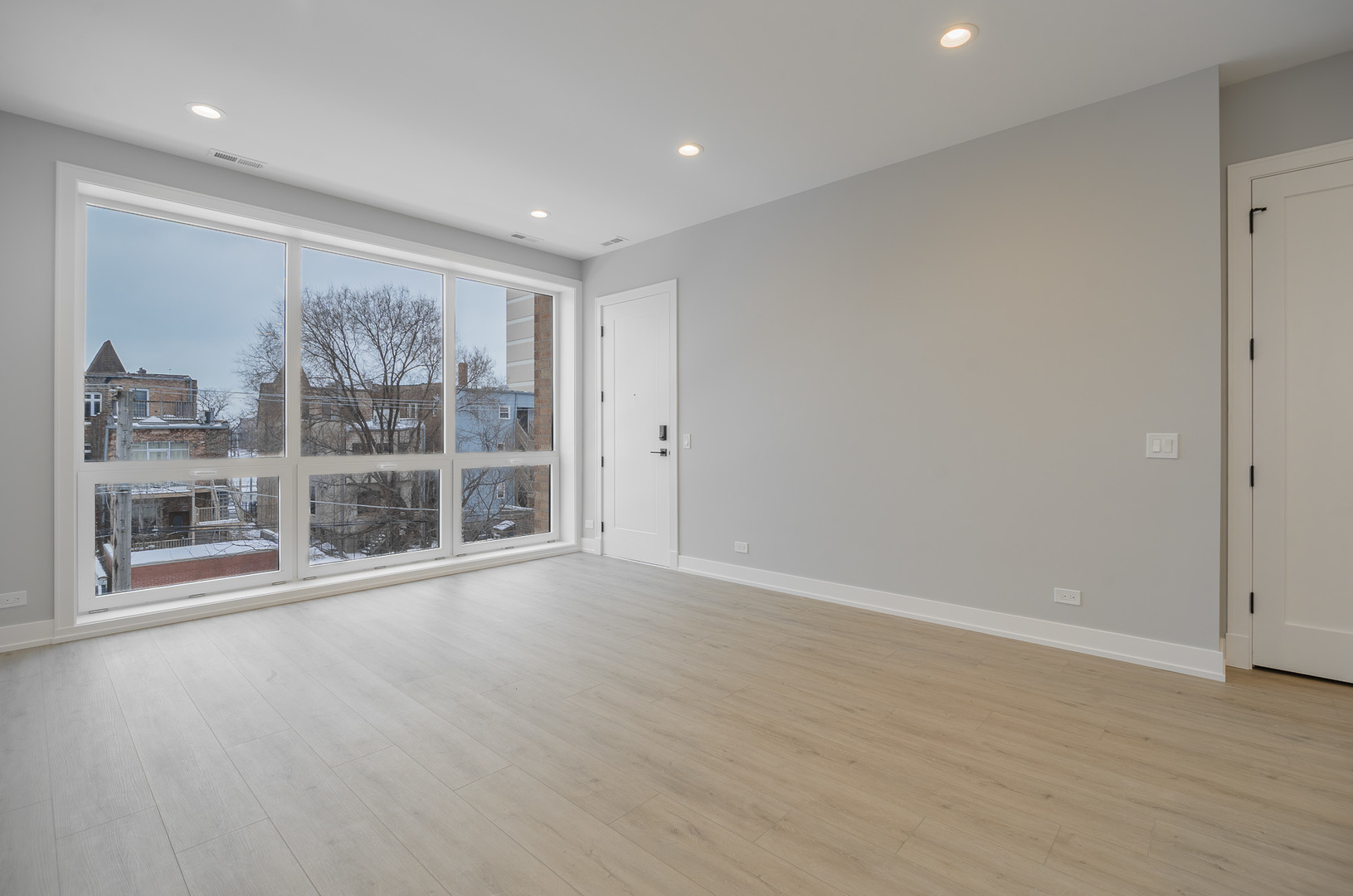 3738 South Calumet Avenue, Unit 2N Chicago, IL 60653 - Photo 4 of 21 a view of an empty room with a window and wooden floor