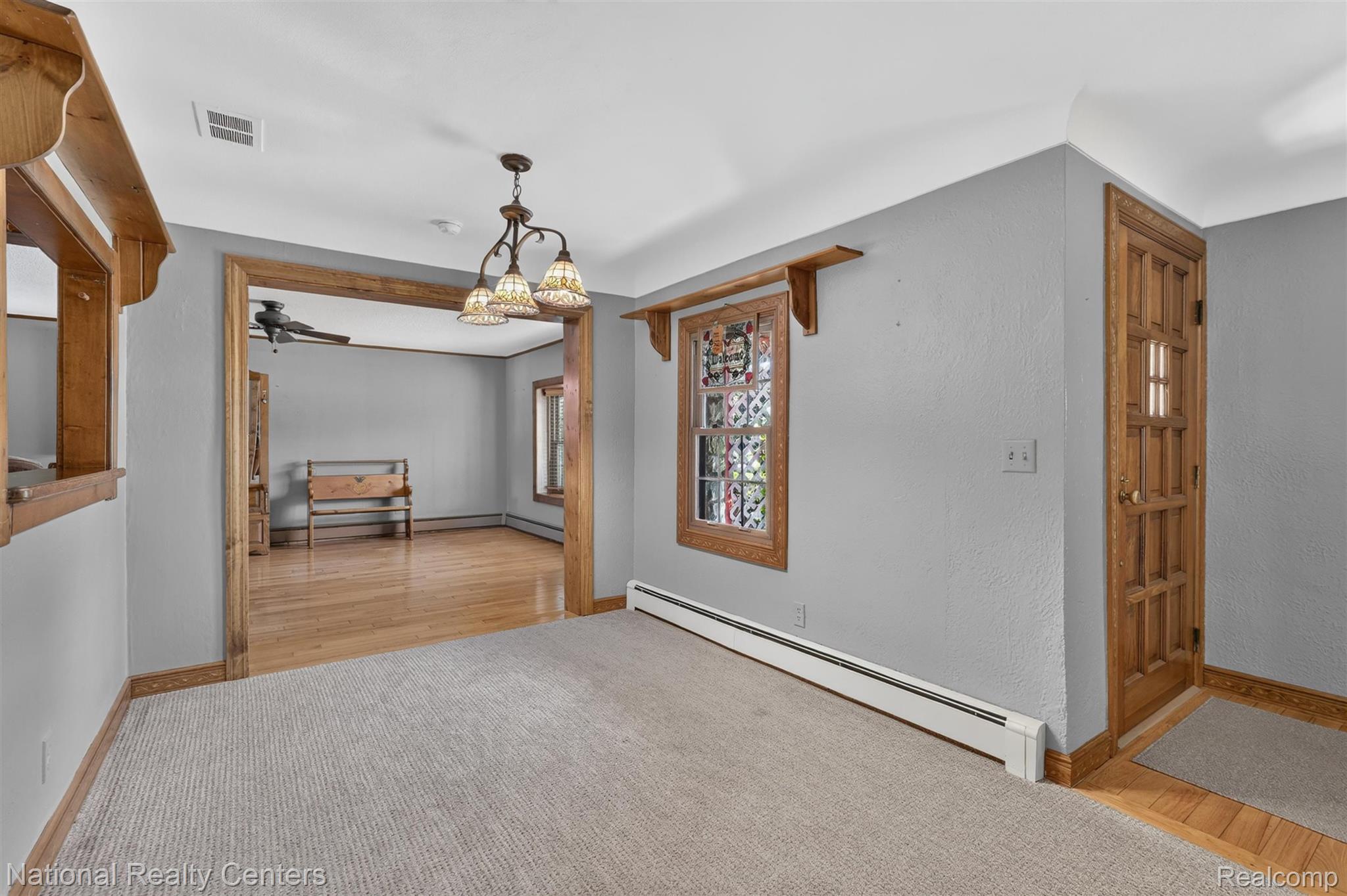 Hardwood flooring, wood trim, decorative light fixture, built-in shelving, paneled door