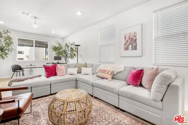 a kitchen with stainless steel appliances granite countertop a dining table chairs a microwave oven and a refrigerator with wooden floor