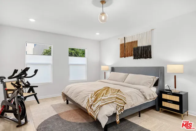 a bedroom with a bed a couch and a chandelier