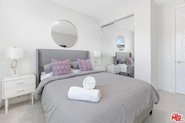 a bedroom with a large bed and a flat screen tv