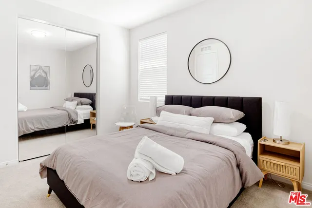 a bedroom with a bed and a lamp on dresser