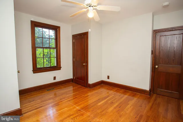 an empty room with window and wooden floor
