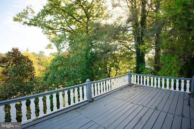 a view of deck with white fence and trees