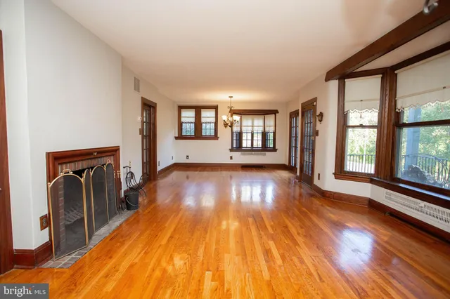 a view of empty room with floor to ceiling window and wooden floor