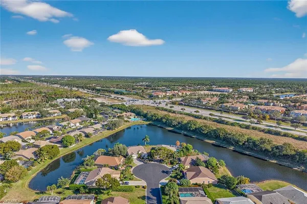 an aerial view of residential houses with outdoor space and lake view