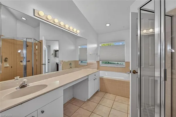 a spacious bathroom with a shower a sink and a mirror