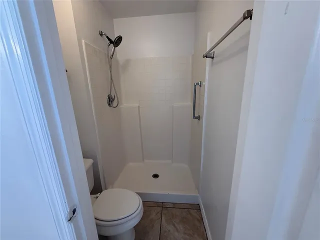 a bathroom with a granite countertop toilet and a shower