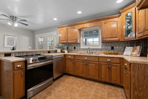 a kitchen with stainless steel appliances granite countertop a stove sink and cabinets