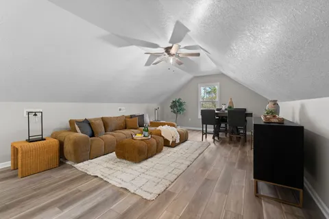 a living room with furniture a ceiling fan and a rug