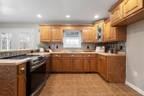a kitchen with a sink stove top oven and cabinets