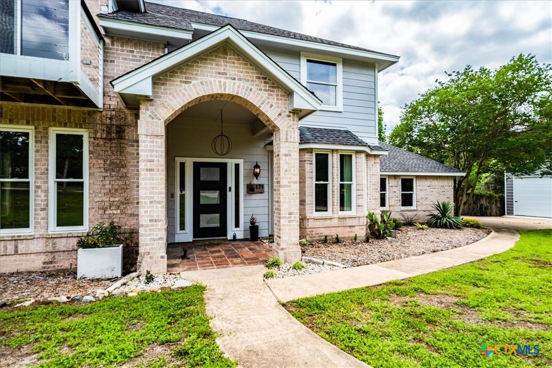 171 Pin Oak Crossing Elgin, TX 78621 - Photo 4 of 38 a front view of a house with yard and seating space