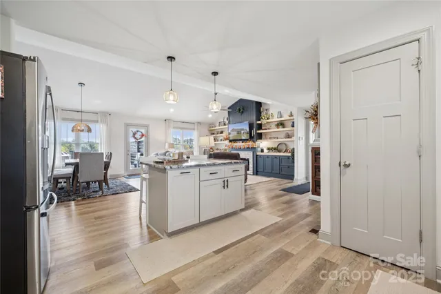 a kitchen with a refrigerator a stove top oven a sink dishwasher and white cabinets with wooden floor