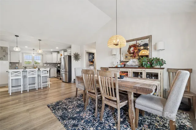a dining room with furniture a chandelier and wooden floor