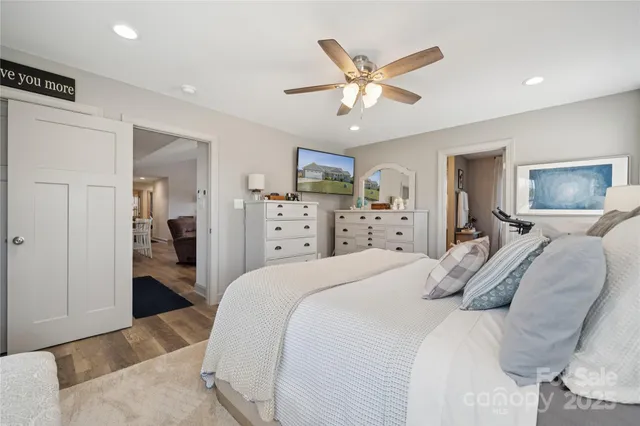 a bedroom with a large bed and a chandelier