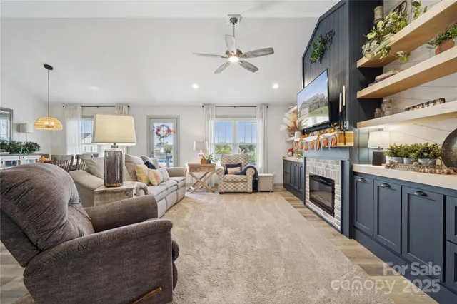 a living room with furniture a fireplace and kitchen view