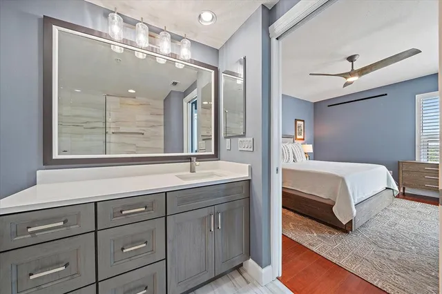 a en suite bathroom with a double vanity sink a large mirror and a shower