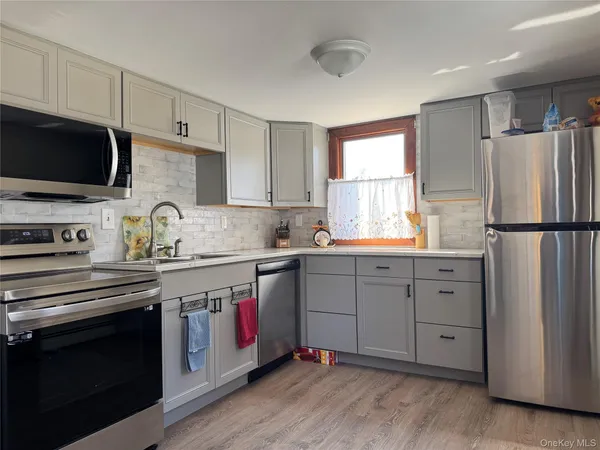 a kitchen with white cabinets sink and stainless steel appliances