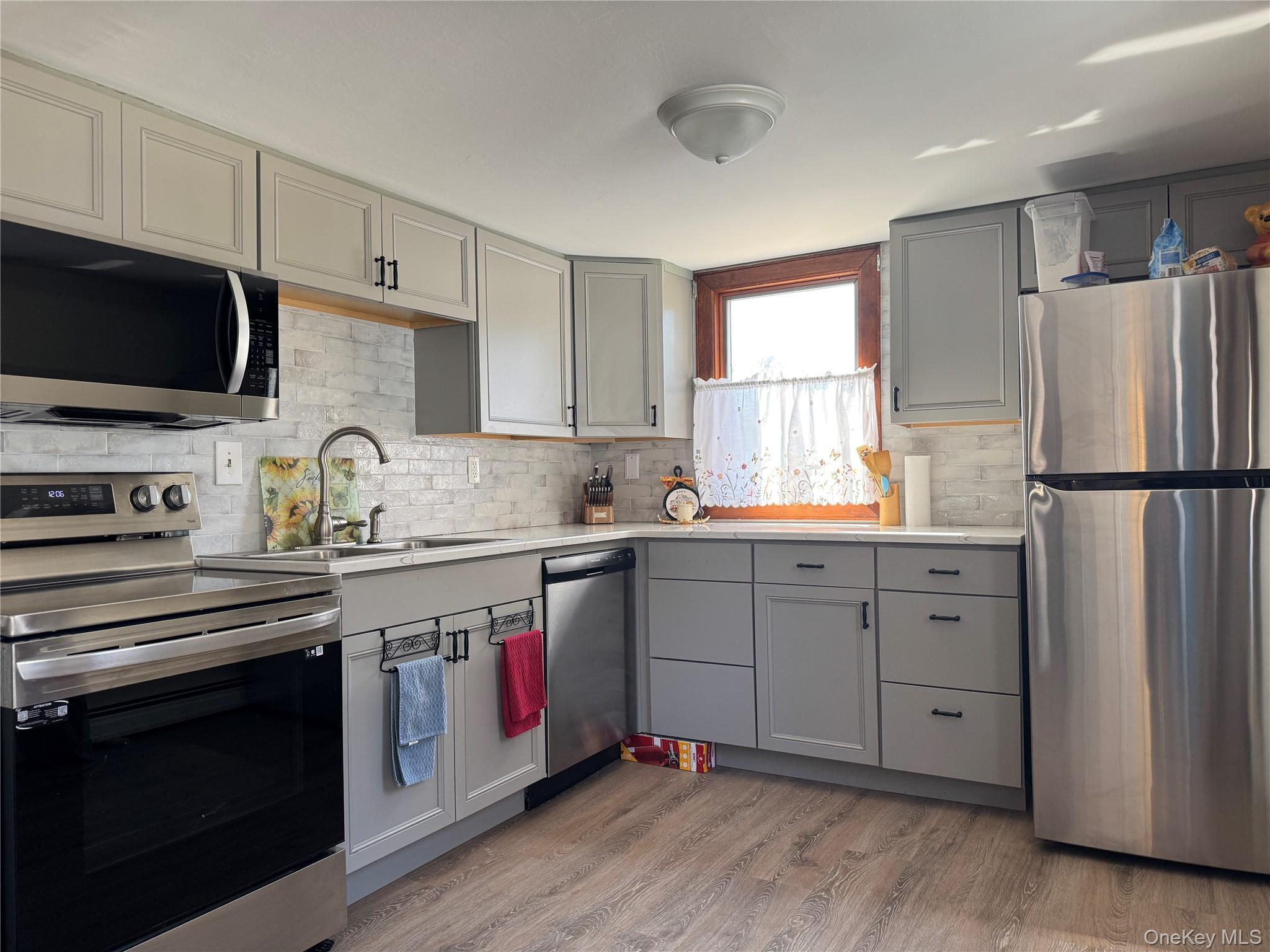 680 Vassar Road Poughkeepsie, NY 12603 - Photo 13 of 21 a kitchen with white cabinets sink and stainless steel appliances