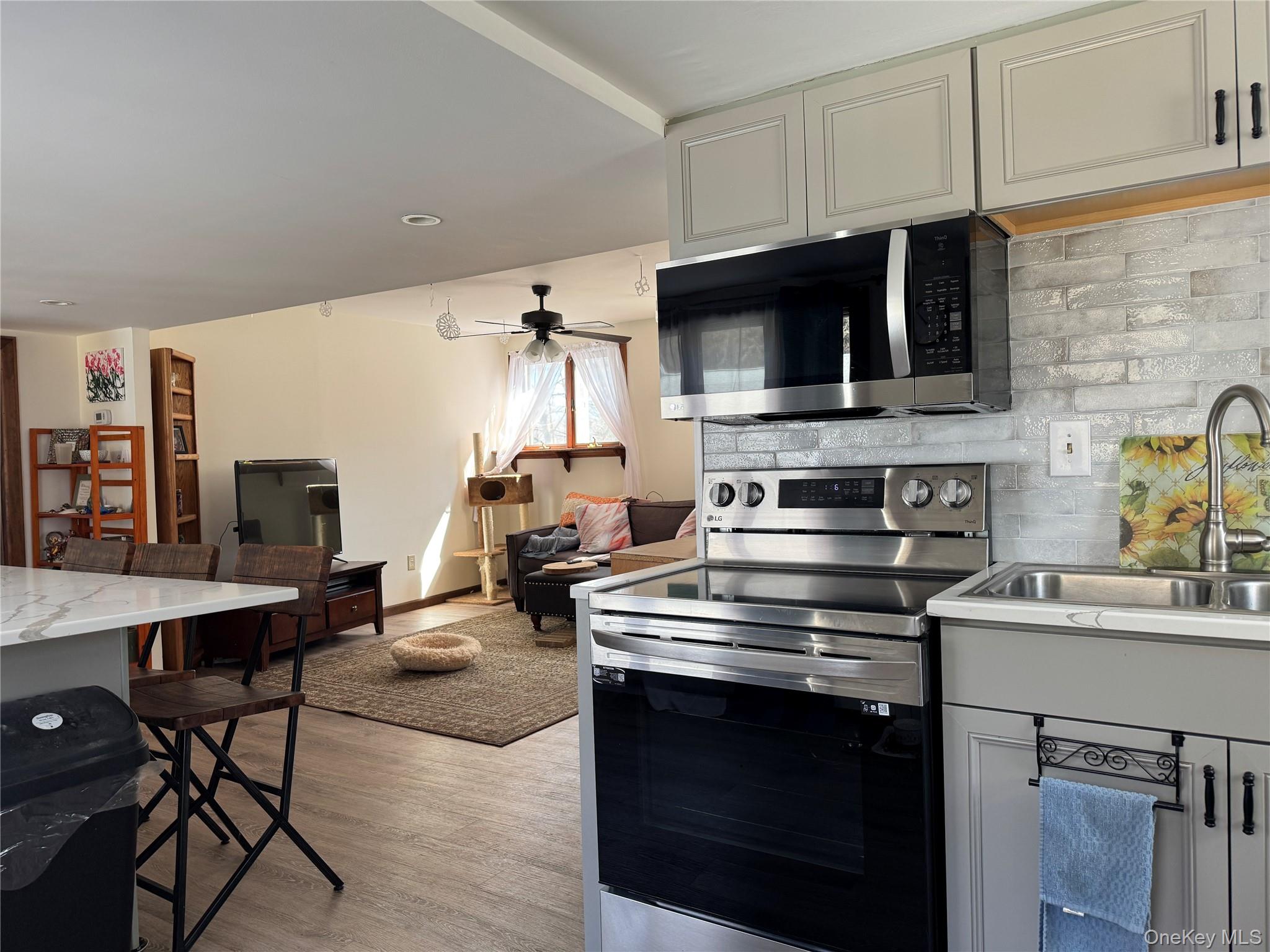 680 Vassar Road Poughkeepsie, NY 12603 - Photo 14 of 21 a kitchen with a stove a microwave and wooden cabinets