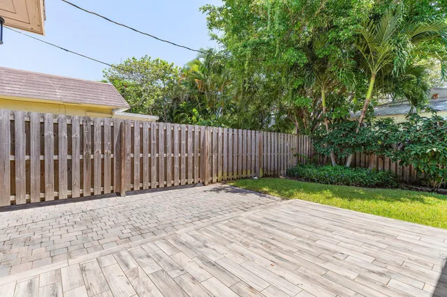 a view of backyard with wooden fence and trees