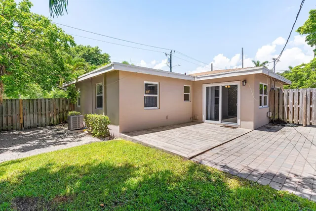 a view of a house with a yard and wooden fence