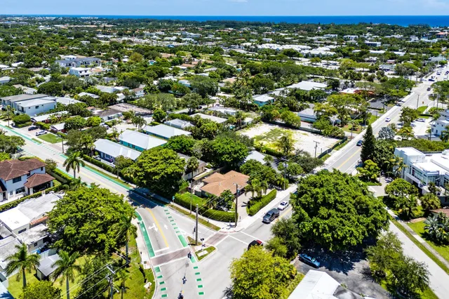 an aerial view of residential houses with outdoor space and trees
