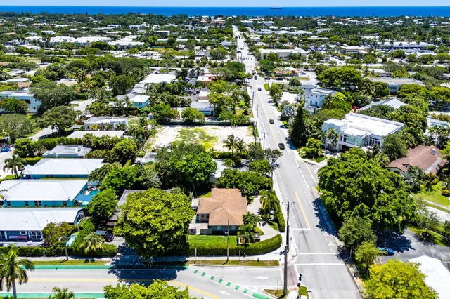 an aerial view of residential houses with outdoor space and trees