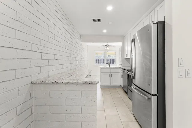 a kitchen with stainless steel appliances granite countertop a sink and a refrigerator