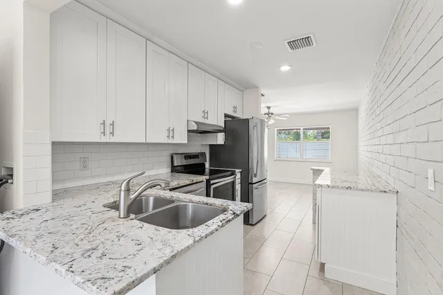 a kitchen with stainless steel appliances granite countertop a sink stove and refrigerator