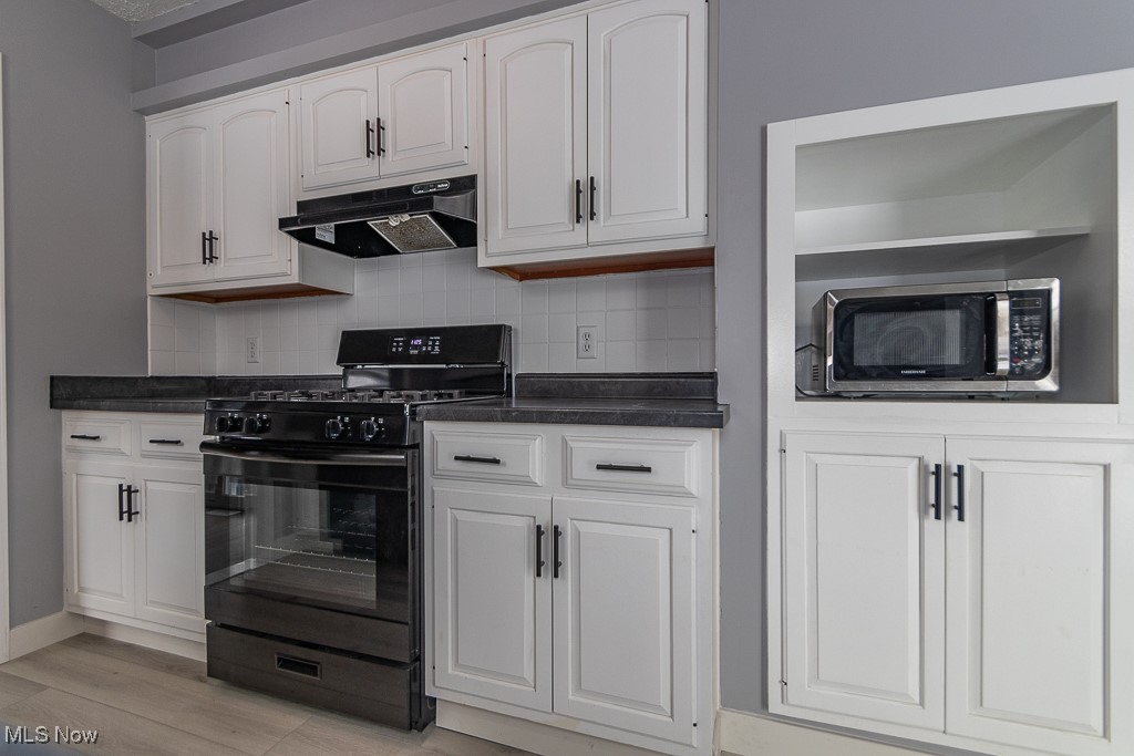 7996 Munson Road Mentor, OH 44060 - Photo 10 of 33 Kitchen with white cabinetry, gas stove, tasteful backsplash, and light wood-type flooring