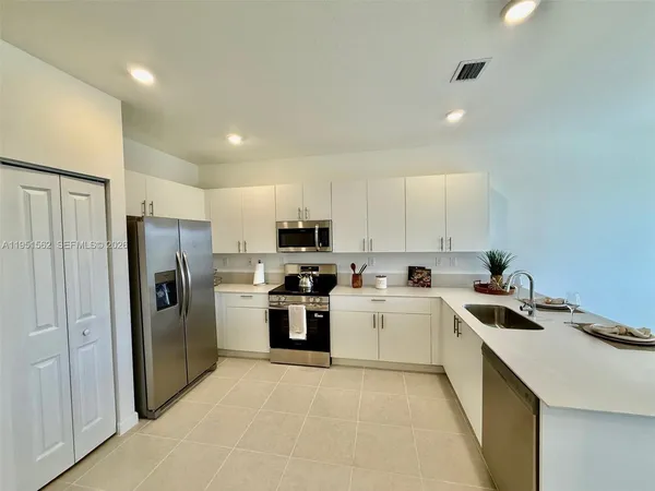 a kitchen with white cabinets and stainless steel appliances
