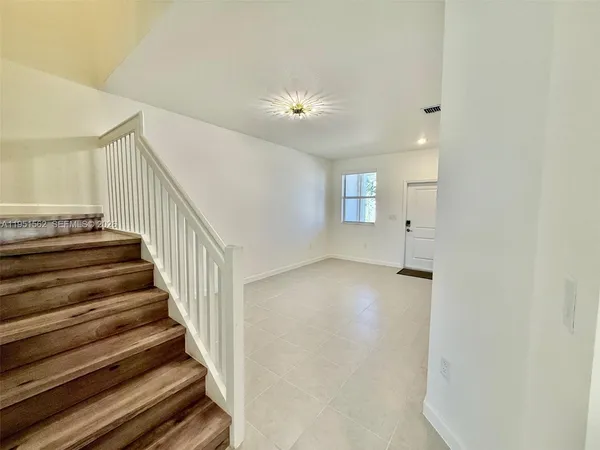 a view of a room with wooden floor and front door