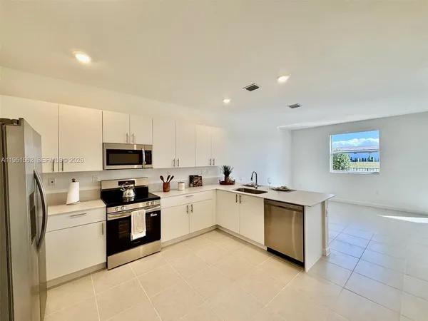 a kitchen with cabinets a sink and white appliances